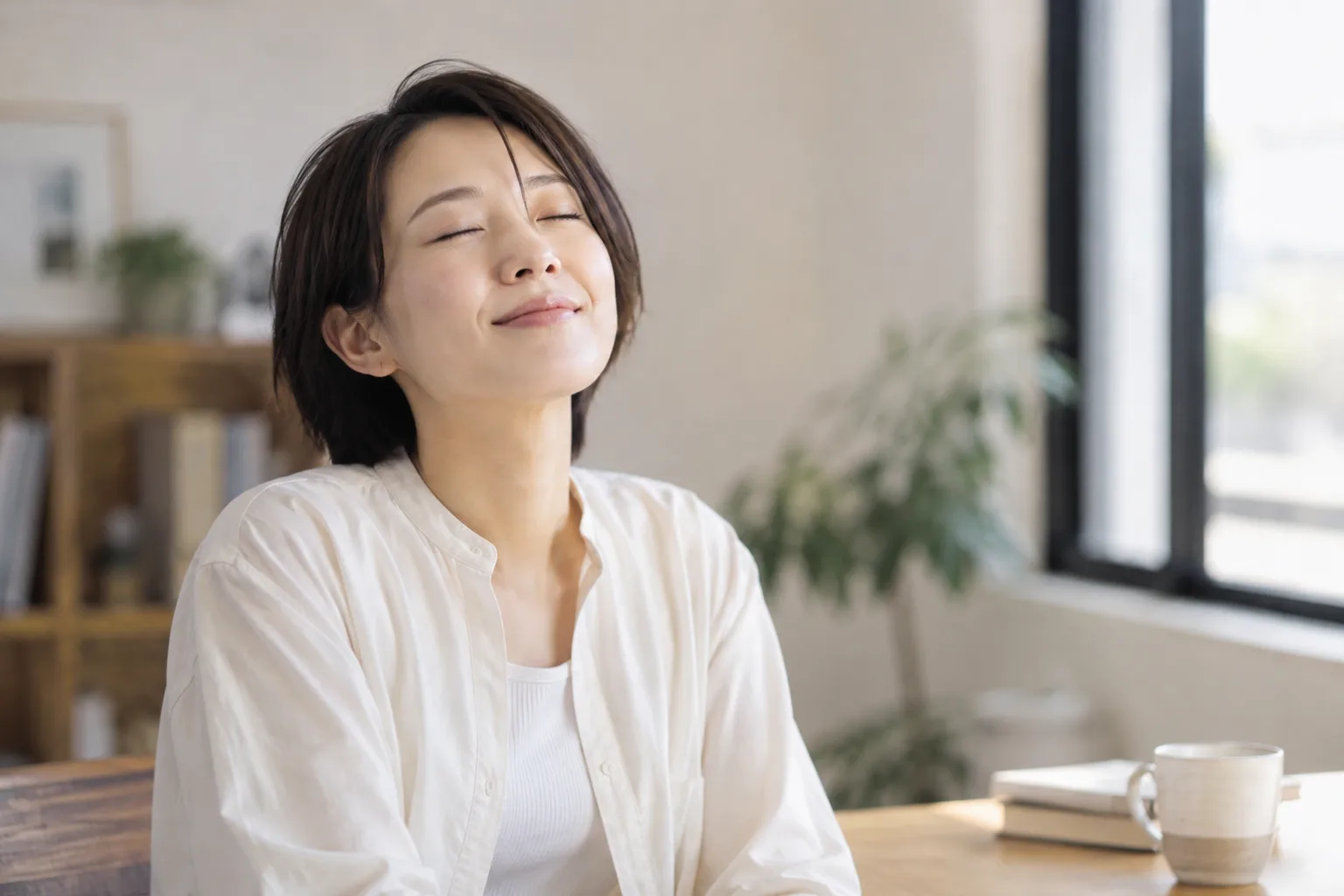 目を閉じて安堵の表情を浮かべ、リラックスして座る女性